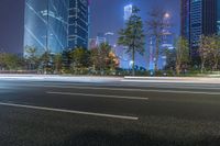 a city street with buildings and neon lights at night time in hong china as seen from an empty city highway