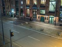 an empty street with an arrow on the road sign at night and people outside on the street