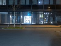 street lights are on in front of an empty parking space at night in a city