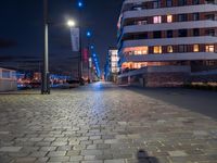 a long narrow cobble stone walkway in the middle of a building next to a street