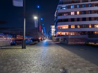 a long narrow cobble stone walkway in the middle of a building next to a street