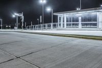 empty public shelter at night with lights on it and concrete flooring on the ground