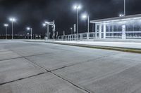 empty public shelter at night with lights on it and concrete flooring on the ground