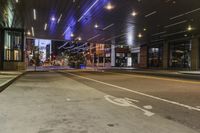a city street at night with lights on both sides of it and empty sidewalks to the side