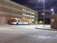 a large yellow bus is parked in the parking lot with other buses behind it and some lights