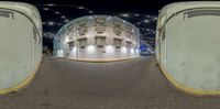 a fish eye view of a circular street scene at night, from the bottom up