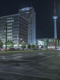 a photo taken at night of a street with a light pole and several other buildings