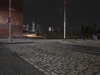 an empty street at night in a city setting with the empire state building visible at the horizon