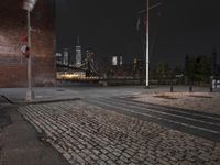 an empty street at night in a city setting with the empire state building visible at the horizon