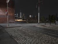 an empty street at night in a city setting with the empire state building visible at the horizon