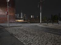 an empty street at night in a city setting with the empire state building visible at the horizon