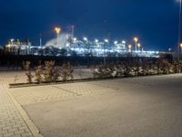 a parking lot next to a stadium at night with lights on the side of the building