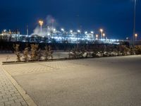 a parking lot next to a stadium at night with lights on the side of the building