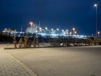 a parking lot next to a stadium at night with lights on the side of the building