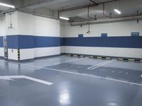 a garage with some parking spaces painted grey blue and white with some cars parked in the middle