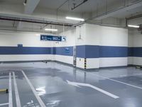 a garage with some parking spaces painted grey blue and white with some cars parked in the middle