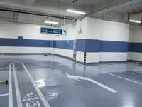 a garage with some parking spaces painted grey blue and white with some cars parked in the middle