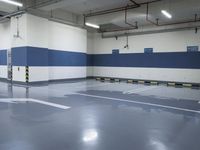 a garage with some parking spaces painted grey blue and white with some cars parked in the middle
