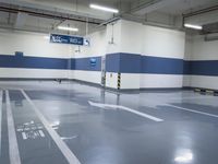 a garage with some parking spaces painted grey blue and white with some cars parked in the middle