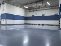 a garage with some parking spaces painted grey blue and white with some cars parked in the middle