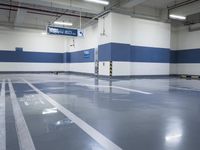 a garage with some parking spaces painted grey blue and white with some cars parked in the middle