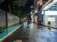 the wet road is lined with parked motorcycles and scooters in the rain at night