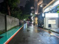 the wet road is lined with parked motorcycles and scooters in the rain at night