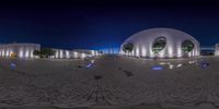 this is a reflection of a building on a cobblestone floor at night, showing the dome entrance and entrance way