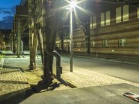 the street has some cars parked next to it at night with a car light on