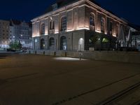 an empty street that has a fire hydrant in the middle of it at night
