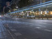 this is an image of a night scene on the street of a city with traffic in motion