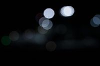 a close up of lights from cars in the dark and blurry image of night