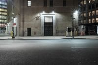 the street that has street lamps, parking meters, and some buildings on it are lit up