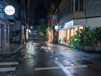 an empty wet city street at night during the day time with rain pouring on the ground