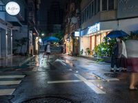 a wet street with a motorcycle parked in front of a large shop at night near street lamps