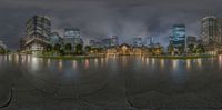 a 360 - view lens shows the city in a park, and the reflection of the buildings on the water