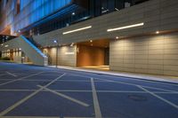 a deserted, empty, street that has blue lights and some stairs on it at night