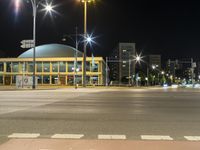 night shot with street lights, large building and road signs at intersection intersection and building