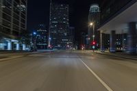 night shot of city streets and buildings in motion with a lens to see the cars driving