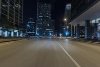 night shot of city streets and buildings in motion with a lens to see the cars driving