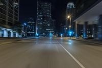 night shot of city streets and buildings in motion with a lens to see the cars driving