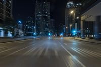 night shot of city streets and buildings in motion with a lens to see the cars driving