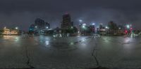 a night shot of a rain soaked intersection and street lights with a few dark streets