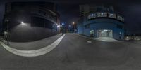 a skate boarder is doing stunts at night near a building and street lights in the dark