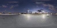 the skateboarder is riding his board up the slope at night time to perform a trick