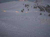 the skier is in front of the lodge at night, with snow on the ground