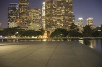 city skyline at night with fire hydrant near the walkway on the right side of it