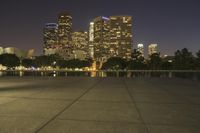 city skyline at night with fire hydrant near the walkway on the right side of it