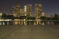 city skyline at night with fire hydrant near the walkway on the right side of it