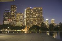 city skyline at night with fire hydrant near the walkway on the right side of it